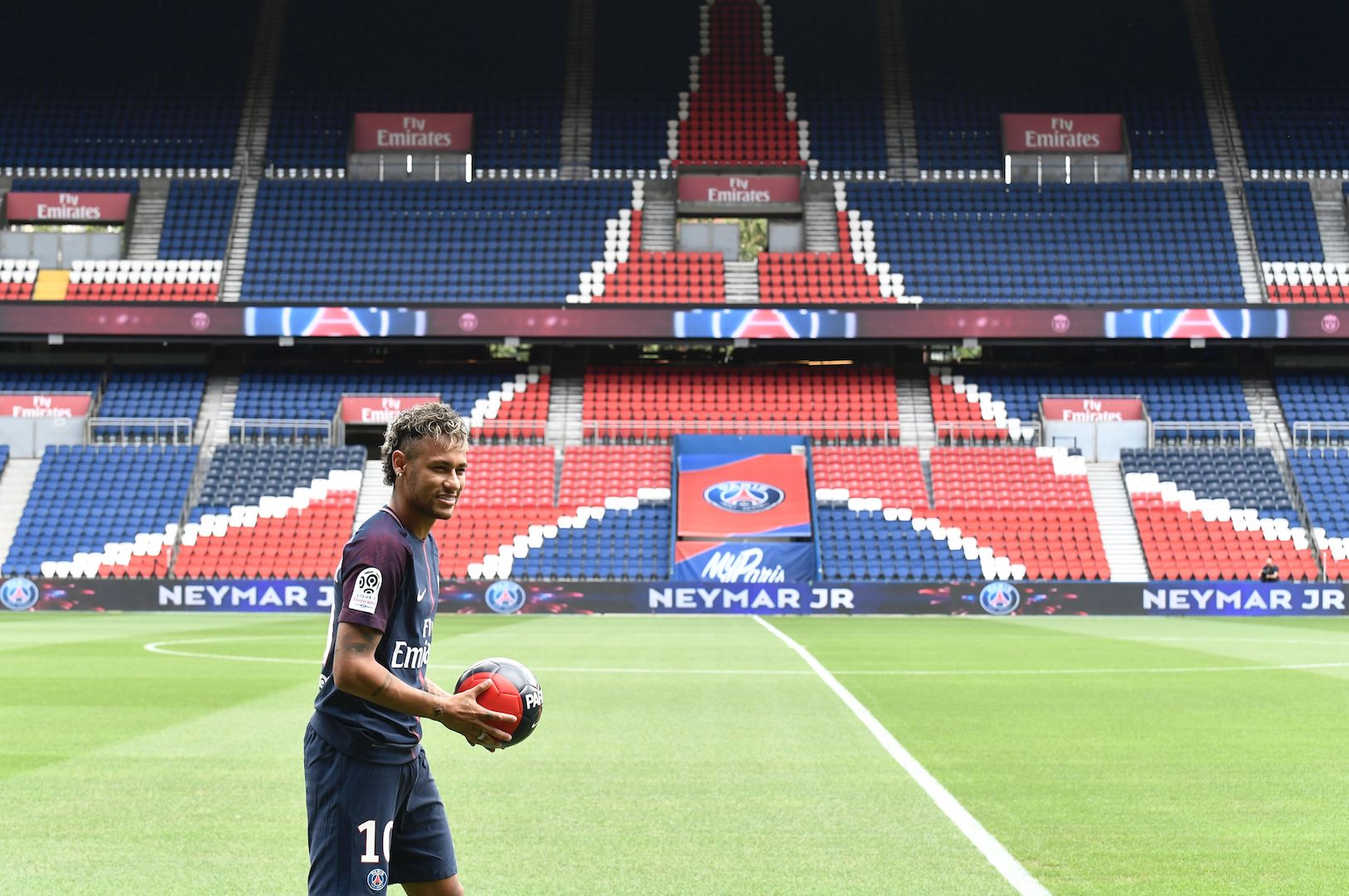 Brazilian superstar Neymar poses with a ball during his official presentation at the Parc des Princes stadium on August 4, 2017 in Paris after agreeing a five-year contract following his world record 222 million euro ($260 million) transfer from Barcelona to Paris Saint Germain's (PSG). Paris Saint-Germain have signed Brazilian forward Neymar from Barcelona for a world-record transfer fee of 222 million euros (around $264 million), more than doubling the previous record. Neymar said he came to Paris Saint-Germain for a "bigger challenge" in his first public comments since arriving in the French capital. / AFP PHOTO / PHILIPPE LOPEZ (Photo credit should read PHILIPPE LOPEZ/AFP/Getty Images)